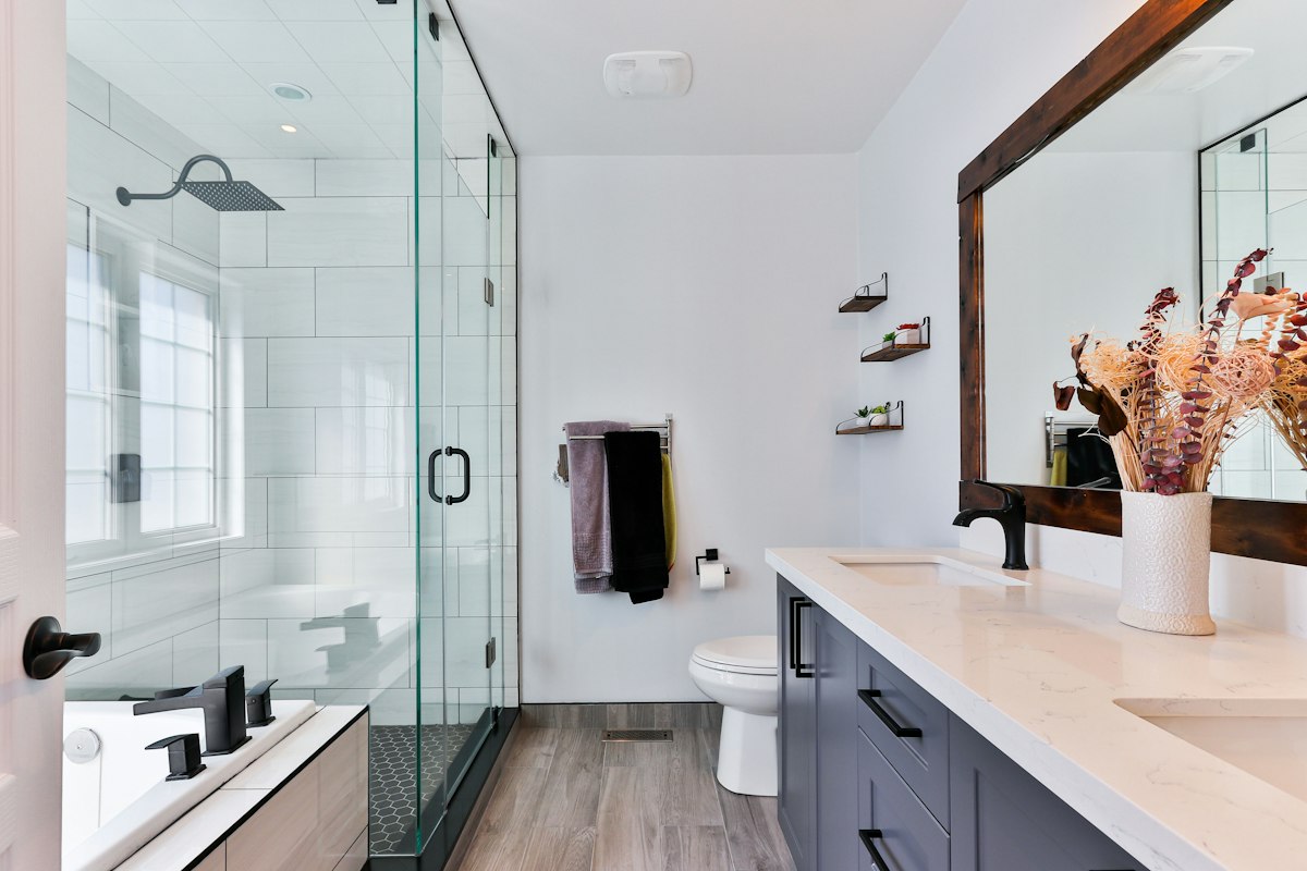 Finished modern bathroom with glass shower, soaking tub, and double vanity