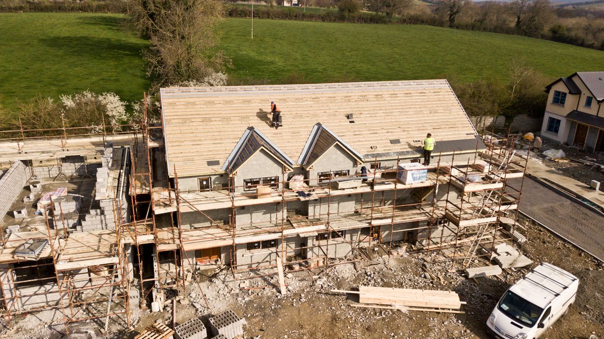 House under construction with roof decking and scaffolding visible
