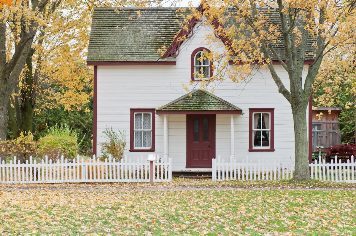 Traditional white farmhouse with horizontal lap siding and red trim